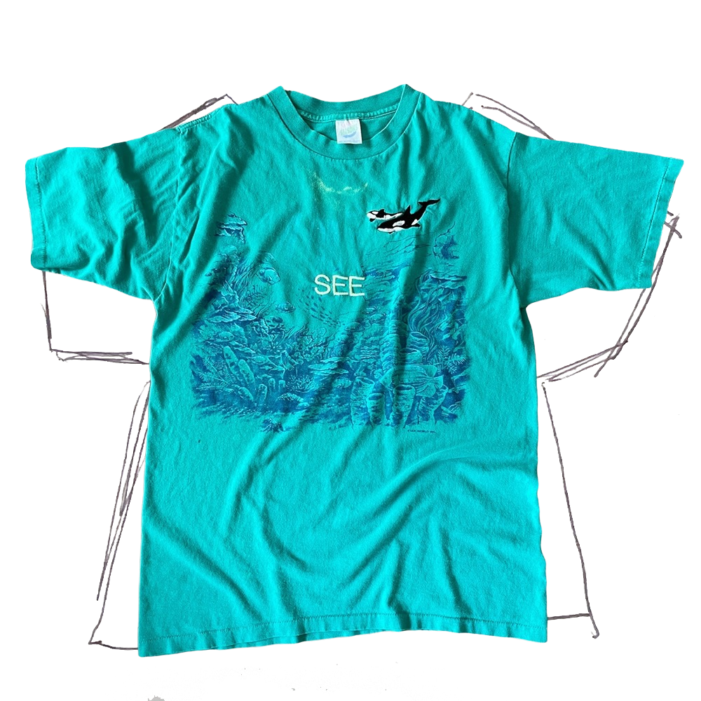 front of tshirt, teal with underwater graphic and original whale (2) embroidery on the upper left chest, with neon light green "see" embroidery in center